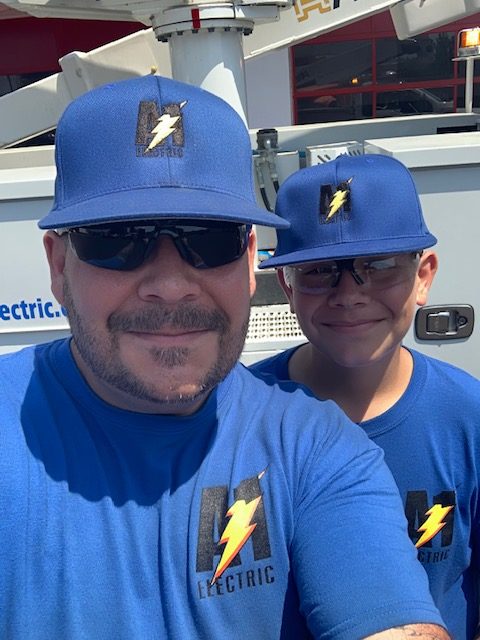 Bill and Thomas Greenage posing with A-1 Electric shirts and hats