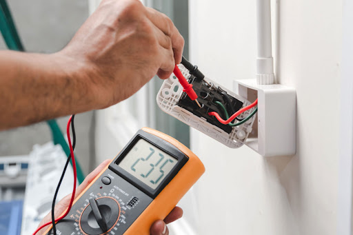 An electrician tests an outlet.