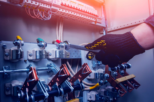 An electrician works on a circuit box.